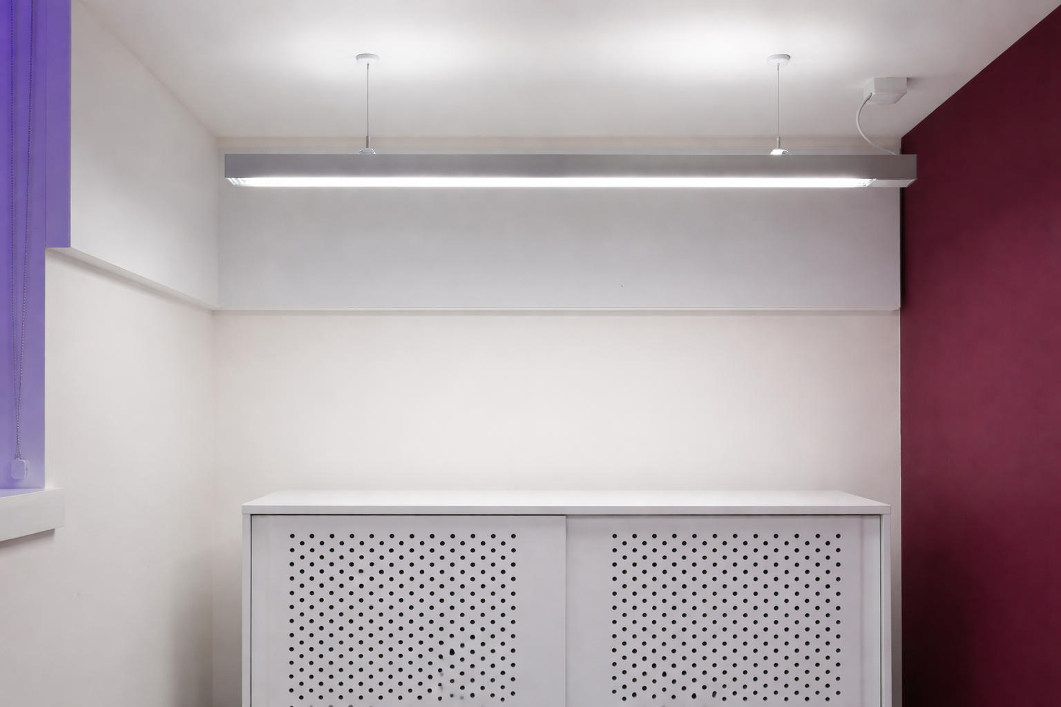 Modern office interior with perforated cabinetry and accent wall